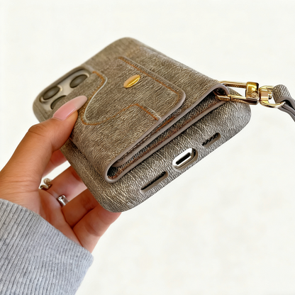 Hand holding a brown textured phone case with a strap on a white background