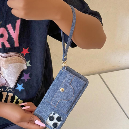 Blue denim phone case with strap held by a person wearing a colorful shirt.