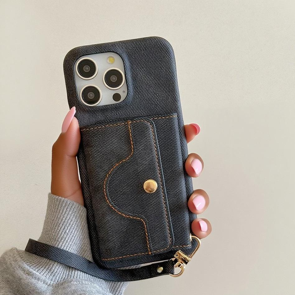 Handmade denim phone case Wallet with a strap against a beige background